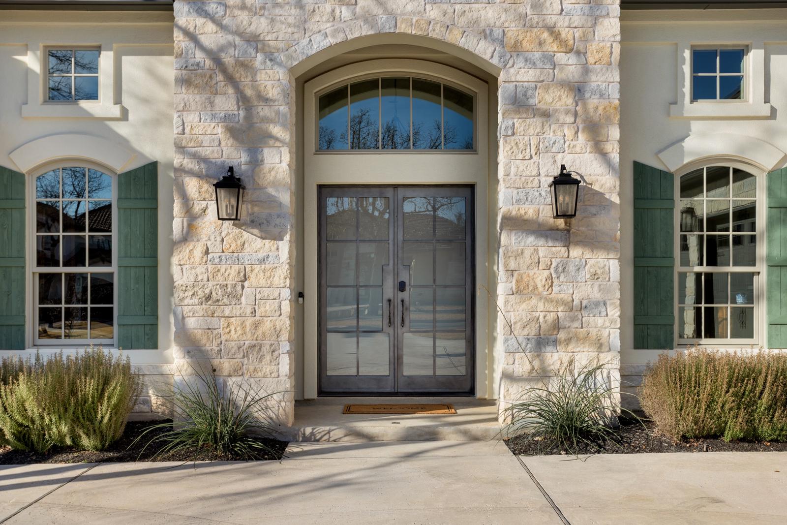 Limestone entry with arched double front doors