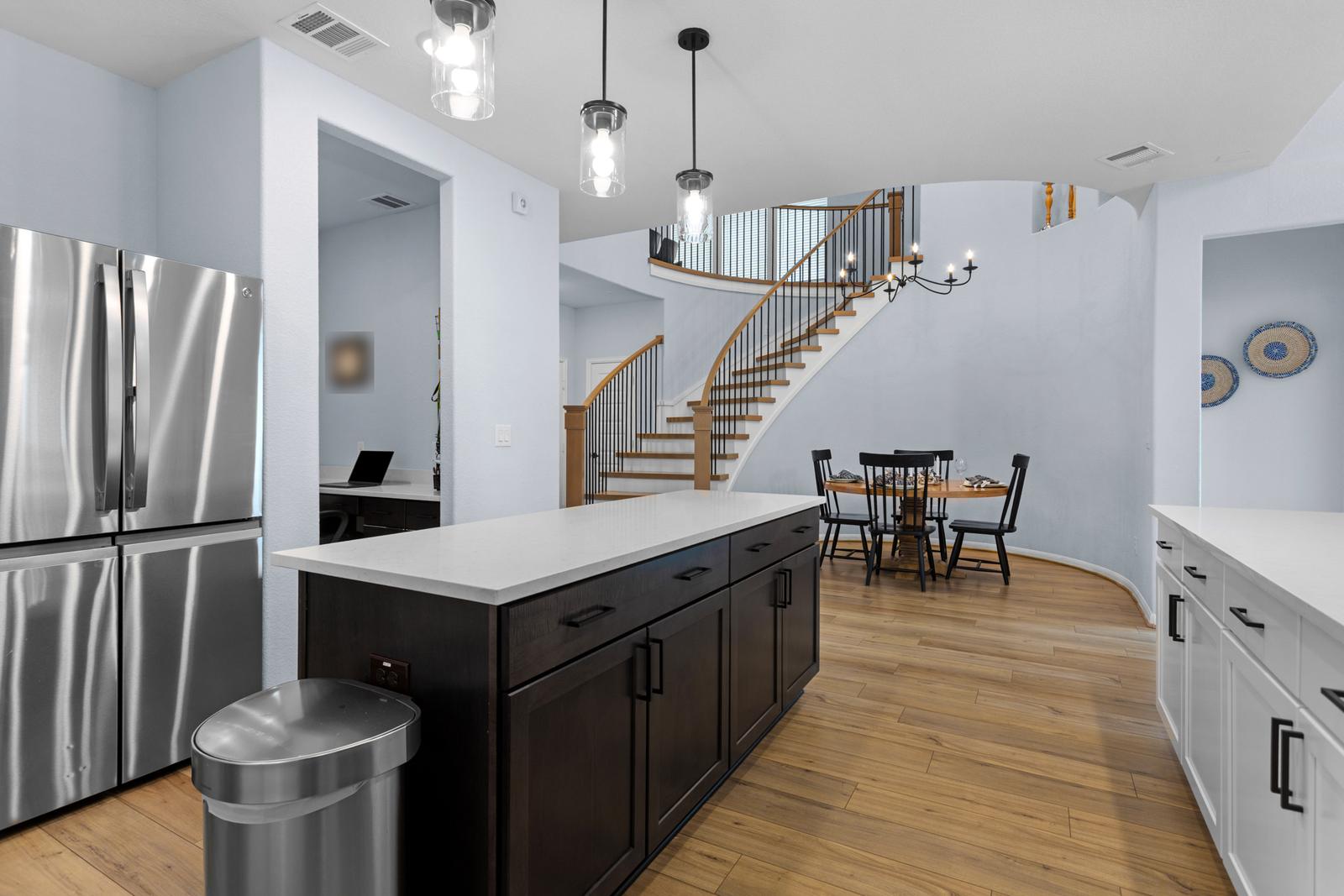 Kitchen with a large island and a curved staircase
